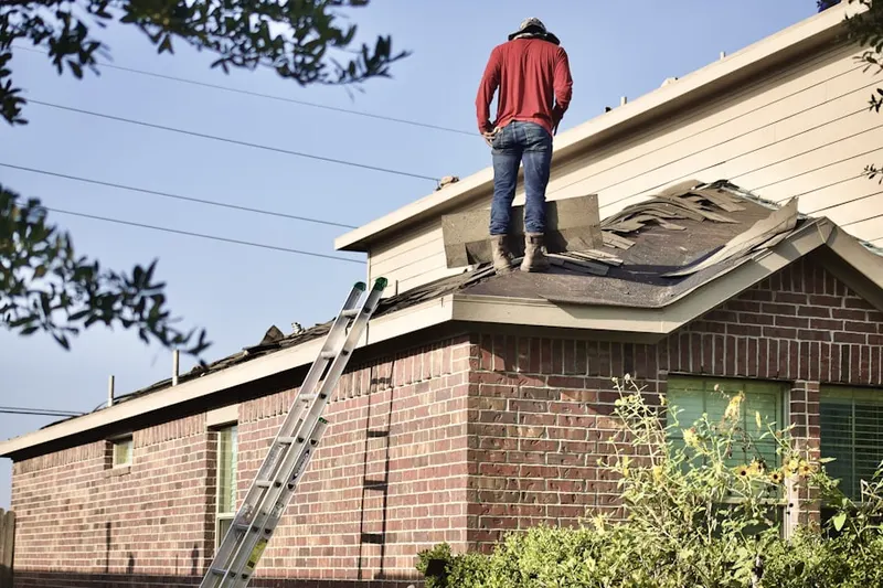 Professional roofer working on a residential roof in Grafton